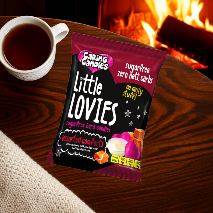 Pack of Caring Candies Little Lovies candies with a cup of tea on a wooden table in front of a fireplace.