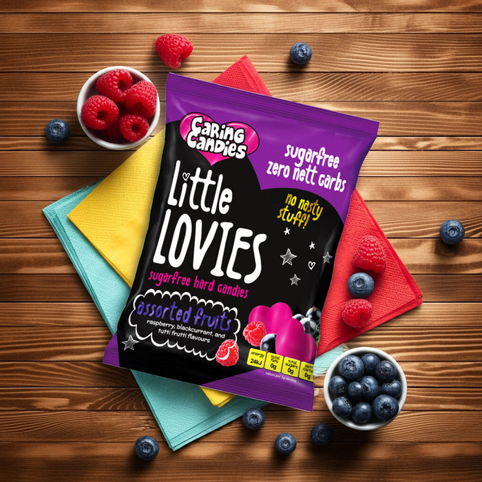 Packaging of sugarfree Caring Candies Little Lovies sweets on a wooden surface with berries around