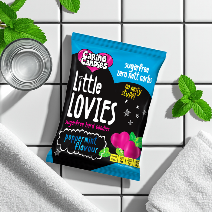 Pack of Caring Candies Little Lovies on a white tiled background with mint leaves.