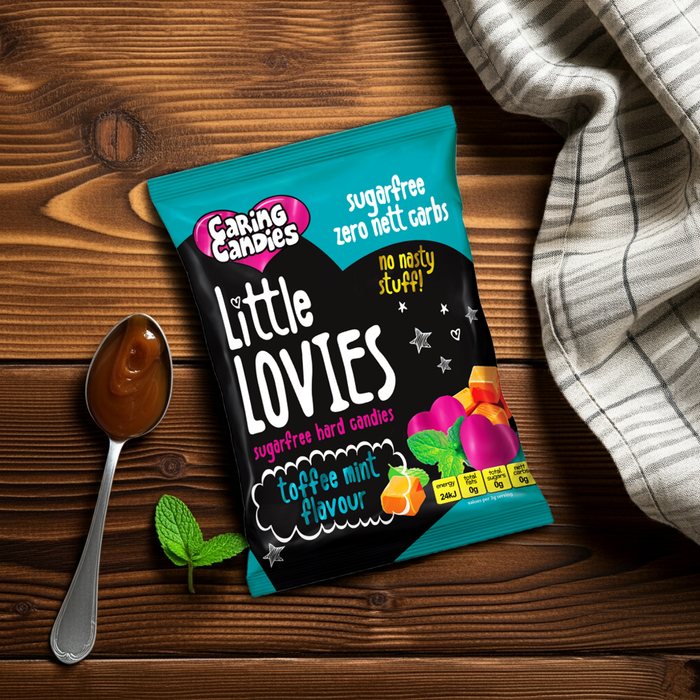 Packaging of Little Lovies candy on a wooden surface with a spoon and mint leaves.