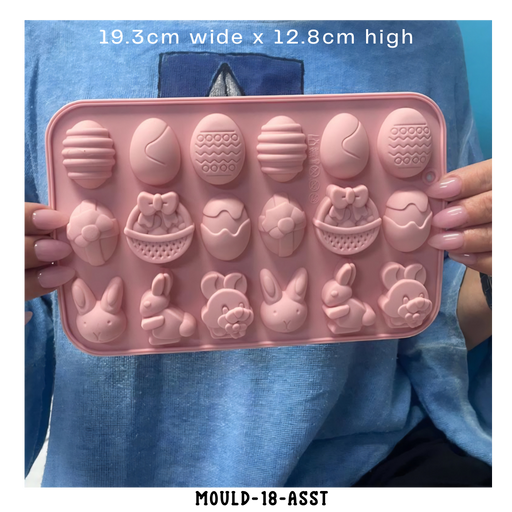 Pink silicone easter chocolate and soap mould with various shapes held by a person wearing a blue shirt.
