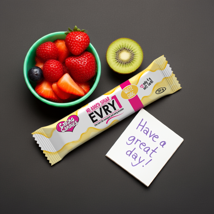 EVRY1 white chocolate bar with a bowl of strawberries and a kiwi, and a 'Have a great day!' note on a dark background