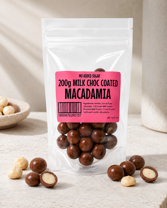 Packaged no added sugar milk chocolate coated macadamia nuts with a pink label on a neutral background