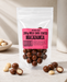 Packaged no added sugar milk chocolate coated macadamia nuts with a pink label on a neutral background