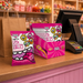 Caring candies Little Lollies packaging on a store counter with a cash register.