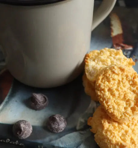 White mug with cookies and chocolate chips on a surface
