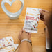 Person holding a Montagu Heart Friendly Mix packet on a wooden table