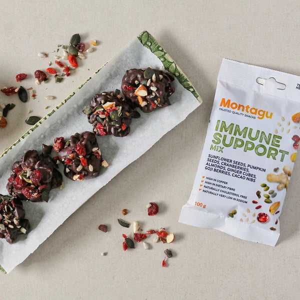 Chocolate snacks with dried fruits and a Montagu immune support mix packet on a neutral background