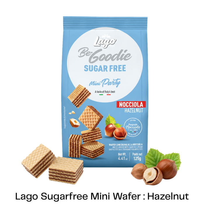 A blue bag of Lago Be Goodie Sugar Free Mini Party Nocciola Hazelnut wafers, shown with several hazelnut-filled wafers and hazelnuts arranged around it on a white background with a black text banner at the bottom.