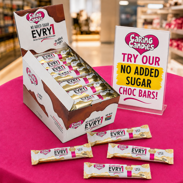 Caring Candies EVRY no added sugar chocolate bars displayed on a pink table with a promotional sign.