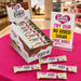 Caring Candies EVRY no added sugar chocolate bars displayed on a pink table with a promotional sign.