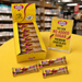 Caring Candies chocolate bars with packaging and promotional signs on a yellow surface.