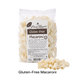 Packet of Glutenfree Pasta Regalo macaroni with uncooked macaroni in front of it
