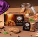Sugar Free Lite Choco-Chip Oat Cookies in a brown box and an individual packet, styled on a brown surface with cookies, oats, chocolate chips, and green leaves.