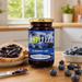 lifestyle photo of Bottle of Yes Pleeze No Added Sugar Blueberry Jam with fresh blueberries scattered around the bottom