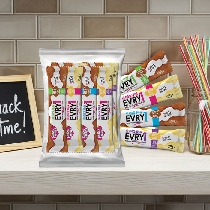 Assorted caring candies EVRY1 sugar-free chocolate bars on a kitchen counter with a chalkboard sign and straws in the background.