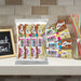 Assorted caring candies EVRY1 sugar-free chocolate bars on a kitchen counter with a chalkboard sign and straws in the background.