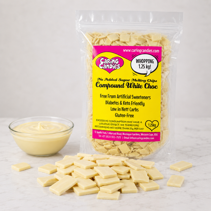 A bag of Caring Candies No Added Sugar Compound White Choc melting chips, with some chips spilled in front and a small bowl of white chocolate on a light marble surface.
