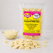 A bag of Caring Candies No Added Sugar Compound White Choc melting chips, with some chips spilled in front and a small bowl of white chocolate on a light marble surface.